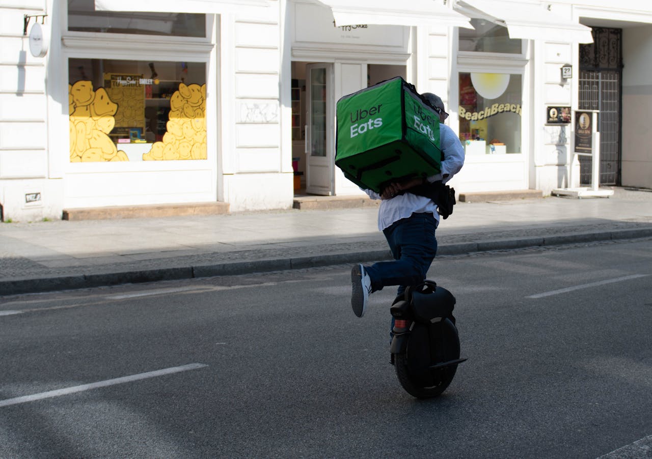 A delivery man rides an electric unicycle with a delivery bag in Warsaw, Poland.